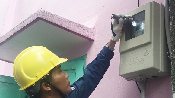 Nhân viên ngành điện kiểm tra việc lắp đặt công tơ đo đếm từ xa mới tại nhà dân