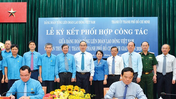 Bí thư Thành ủy TPHCM Nguyễn Thiện Nhân chứng kiến lễ ký kết giữa Phó Bí thư Thường trực Thành ủy TPHCM Trần Lưu Quang và Chủ tịch Tổng Liên Đoàn Lao Động Việt Nam Nguyễn Đình Khang. Ảnh: VIỆT DŨNG