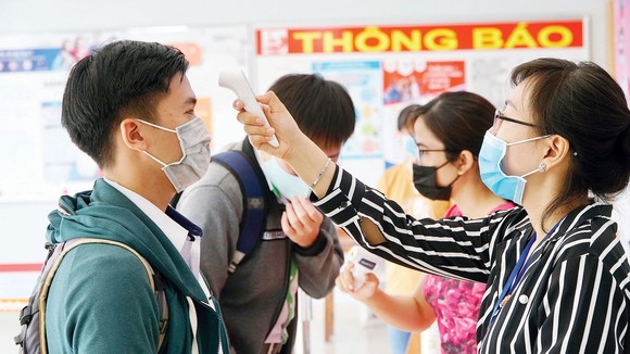 Đo thân nhiệt thí sinh tại điểm thi Trường THPT Gia Định, quận Bình Thạnh, TPHCM. Ảnh: QUANG PHÚC - HOÀNG HÙNG