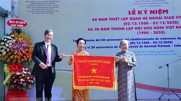 Ông Vương Đức Hoàng Quân, Chủ tịch Liên hiệp các tổ chức hữu nghị TPHCM, trao Cờ truyền thống của UBND TP tặng Hội hữu nghị Việt Nam-Cuba TPHCM. Ảnh: TTXVN