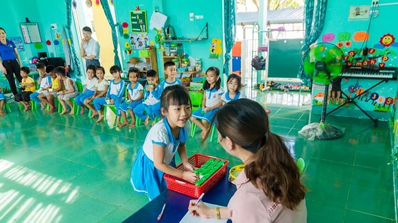Các em học sinh trường Tiểu học thực hành thao tác gấp vỏ hộp sau khi uống sữa