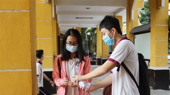 Học sinh rửa tay bằng dung dịch sát khuẩn trước khi vào lớp. (Ảnh: Xuân Anh/TTXVN)
