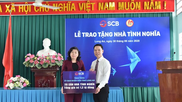 Ông Đinh Văn Thành – Chủ tịch HĐQT SCB trao bảng tượng trưng trao 20 căn nhà tình nghĩa tại Long An.