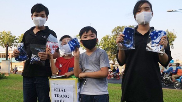 Nhóm học sinh phát khẩu trang vải miễn phí cho người đi đường
