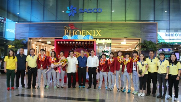 Lãnh đạo LĐBĐ TPHCM, Trung tâm thể thao Quận 1 cùng đại diện đội nữ TPHCM chúc mừng cô trò HLV Kim Chi tại sân bay Tân Sơn Nhất. Ảnh: HỮU THỊNH