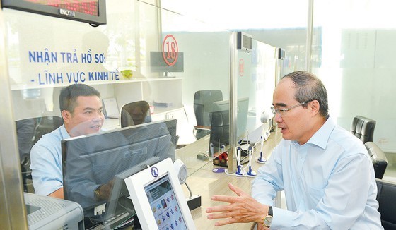 Secretary of HCMC Party Committee Nguyen Thien Nhan talks with an official of the People’s Committee of District 12.