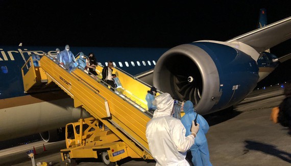Vietnamese people return home on a repatriation flight in Van Don Airport. (Photo: SGGP)