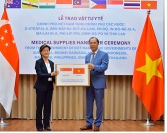 Singaporean Ambassador Catherine Wong Siow Ping (left) receives a donation of Reverse Transcription Polymerase Chain Reaction test kits from Vietnamese Deputy Foreign Minister Nguyen Quoc Dung in May.