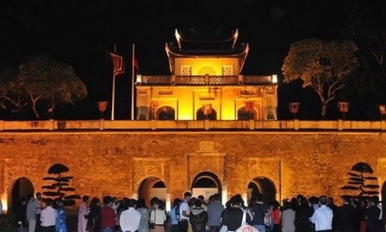Visitors stand in front of Doan Mon (Main Gate) of the Thang Long Imperial Citadel in the evening (Photo: VNA)