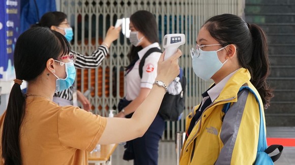 Kiểm tra thân nhiệt tại điểm thi THPT Gia Định - quận Bình Thạnh. Ảnh: HOÀNG HÙNG