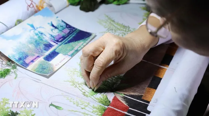 Giữa nhịp sống hối hả, người dân xã Thư Trì, tỉnh Hưng Yên vẫn cần mẫn, miệt mài bên khung thêu, tỉ mỉ từng đường kim mũi chỉ để giữ nghề truyền thống. (Ảnh: Thế Duyệt/TTXVN)