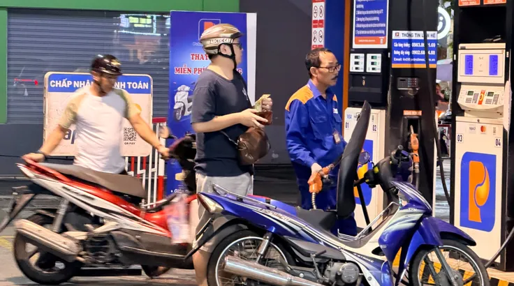 Người dân đổ xăng tại cửa hàng xăng dầu Petrolimex 26, phường Xuân Hòa, TPHCM, tối 6-3 (ẢNH: HOÀNG HÙNG)