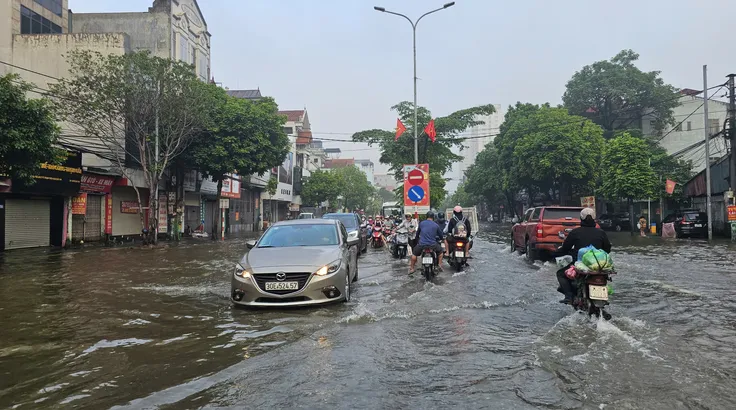Sáng 19-9, nhiều đoạn trên quốc lộ 32 vẫn chìm trong nước. Ảnh: TIẾN CƯỜNG