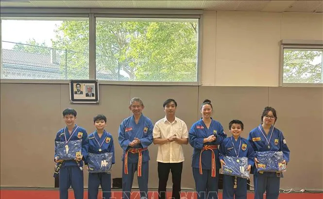 Chủ tịch CLB Thăng Long Thủy Tiên (thứ ba từ phải sang) cùng cha của mình (thứ ba từ trái qua) và đại diện TTVH Việt Nam tại Pháp, trao thưởng cho học viên có thành tích cao của CLB. Ảnh: TTXVN