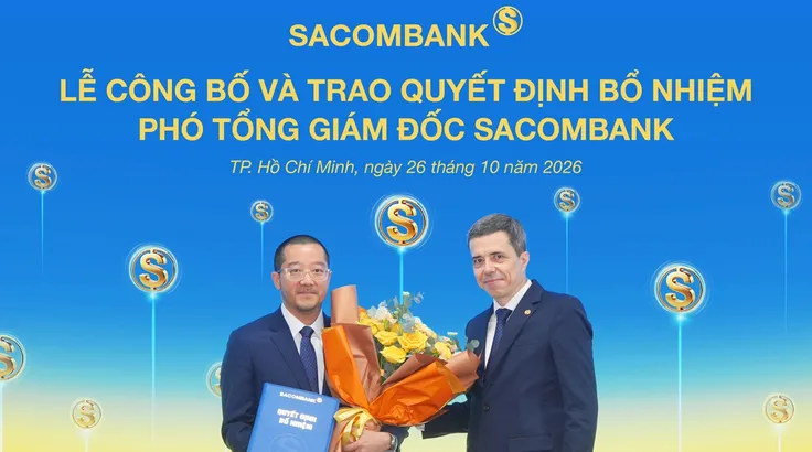 Ông Nguyễn Xuân Ái Quốc nhận quyết định bổ nhiệm và hoa chúc mừng từ ông Loic Faussier - Tổng giám đốc Sacombank