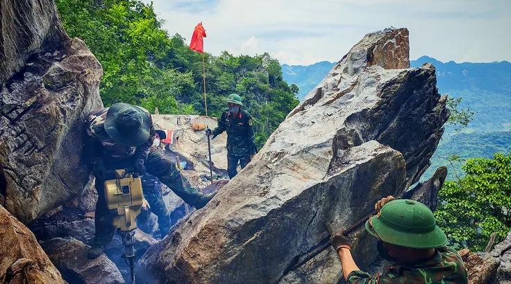 Cán bộ, chiến sĩ khoan đá tìm kiếm những dấu tích về các liệt sĩ đang nằm lại trên điểm cao 685 của mặt trận Vị Xuyên năm xưa. ẢNH: TRẦN LƯU