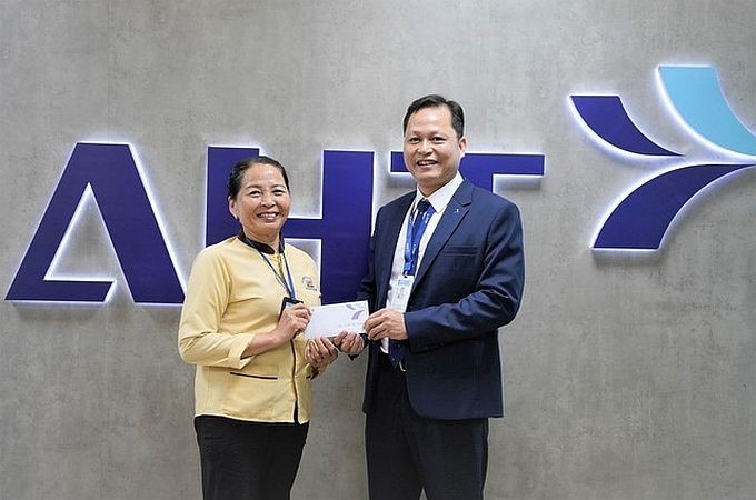 拾金不昧的香姐（左）受到岘港国际机场领导的临时奖励。（图：L.T）