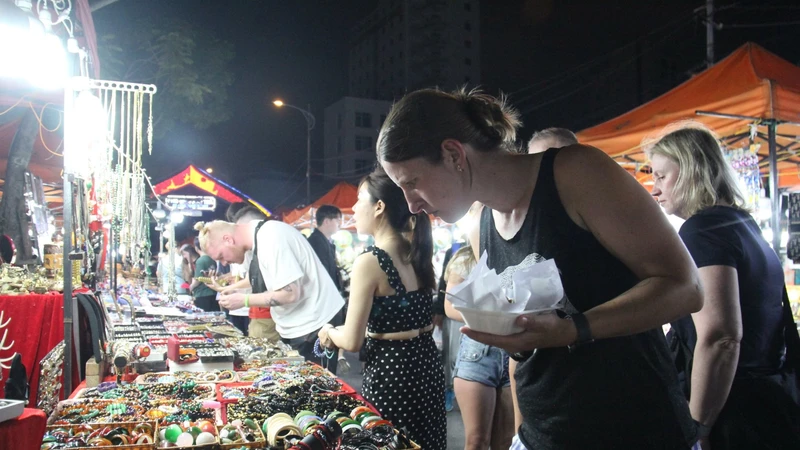 Du khách nước ngoài đến tham quan, thưởng thức ẩm thực tại chợ đêm Sơn Trà. Ảnh: XUÂN QUỲNH