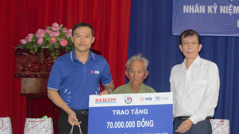 Journalist Nguyen Khac Van, Deputy Editor-in-Chief in charge of Sai Gon Giai Phong Newspaper (R) and a representative of the sponsors provide funding to build and repair houses for wounded veteran Pham Van Thien. (Photo: SGGP)