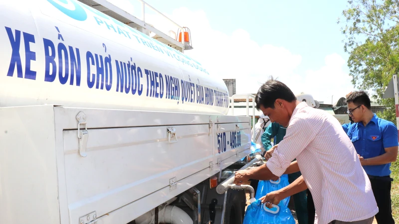 Người dân huyện Tân Phú Đông lấy nước sạch từ xe bồn hỗ trợ nước của SAWACO