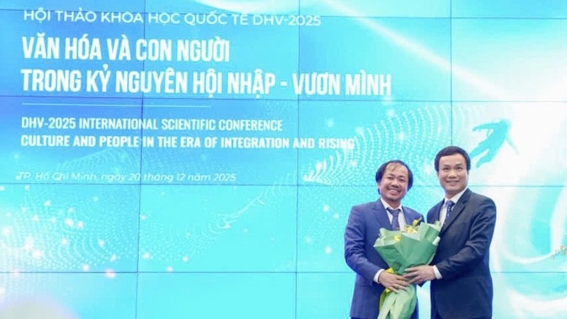 雄王大学校务委员会常务副主席、副校长陈越英博士（左）向国会文化、教育委员会副主任、副教授、博士赵世雄赠送鲜花。