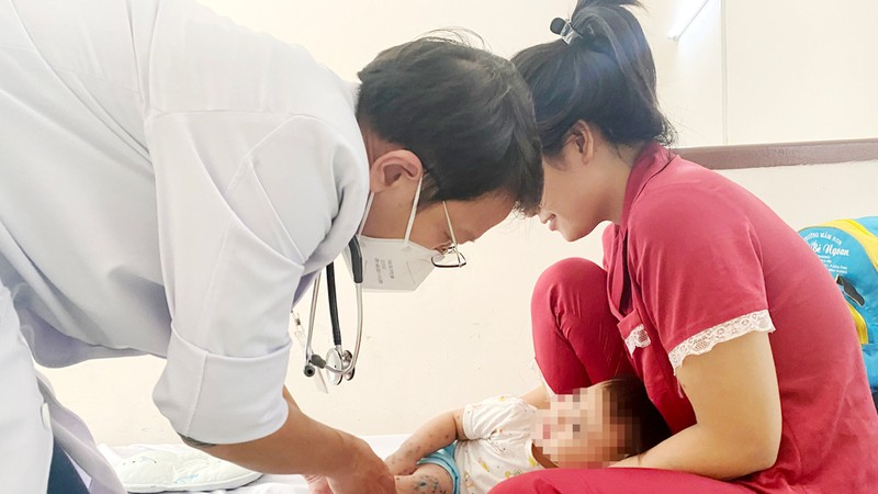 医生正为手足口病童检查。