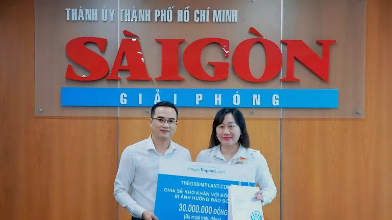 Bà Bùi Thị Hồng Sương, Phó tổng Biên tập Báo Sài Gòn Giải Phóng tiếp nhận 30 triệu đồng chia sẻ khó khăn với đồng bào bị ảnh hưởng bão số 10 (Bualoi) từ ông Nguyễn Thanh Hiền, Giám đốc điều hành Thegioiimplant.com Ảnh: VIỆT NGA 