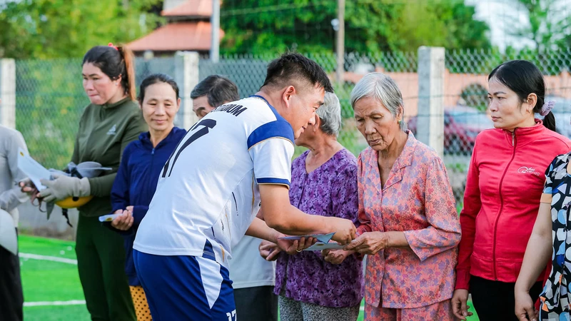 Cầu thủ Nguyễn Văn Cáp, đại diện các đội tham dự giải trao tặng những phần quà đến bà con khó khăn tại huyện Long Đất.