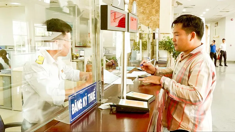 Người dân làm thủ tục thuế. Ảnh: HOÀNG HÙNG