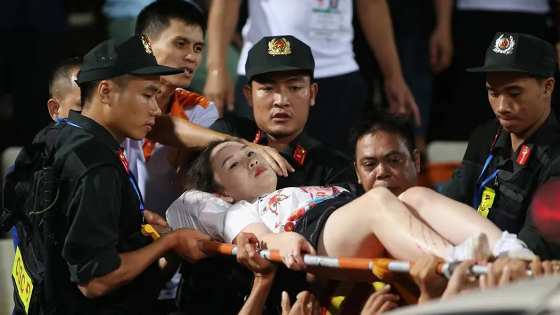 Nữ CĐV được đưa đi bệnh việni. Ảnh: VĂN LÂM