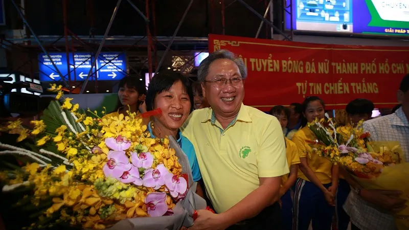 Ông Mai Bá Hùng trao hoa chúc mừng HLV Kim Chi và toàn đội tại sân bay Tây Sơn Nhất tối 5-10. Ảnh: DŨNG PHƯƠNG
