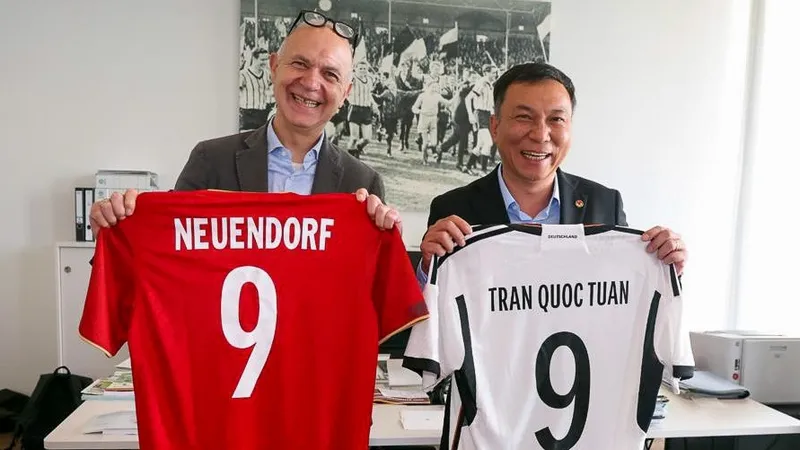 Ông Trần Quốc Tuấn và ông Bernd Neuendorf trao tặng cho nhau áo thi đấu của đội tuyển hai nước