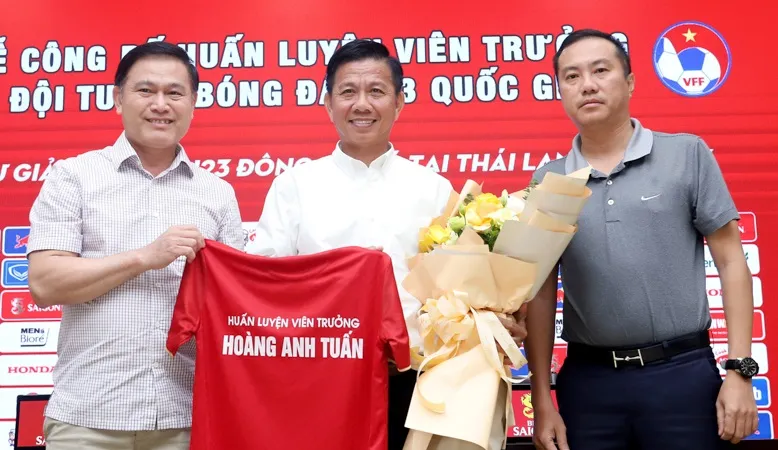 Hai phó chủ tịch VFF Trần Anh Tú và Nguyễn Xuân Vũ tráo tặng áo và hoa đến HLV Hoàng Anh Tuấn