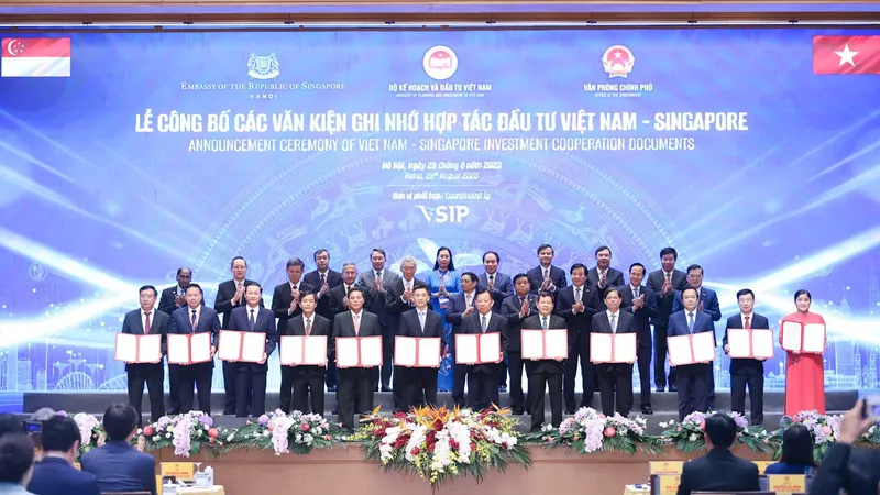 Công bố các văn kiện ghi nhớ hợp tác đầu tư Việt Nam – Singapore với sự chứng kiến của Thủ tướng Nước CHXNCN Việt Nam Phạm Minh Chính (hàng giữa thứ 5 bên phải qua); Thủ tướng Nước Cộng hòa Singapore Lý Hiển Long (hàng giữa thứ 5 bên trái qua)