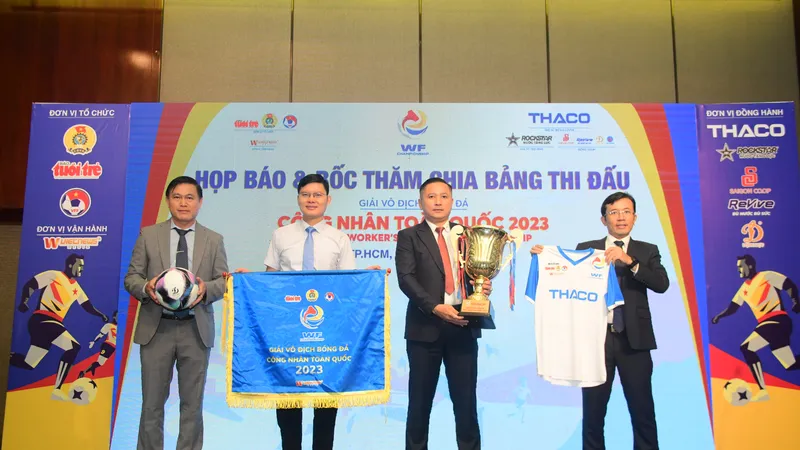 Các đại biểu tham dự buổi họp báo cùng ban tổ chức giới thiệu bóng thi đấu, trang phục thi đấu, Cúp cho đội vô địch...