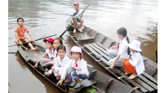 Học sinh Cà Mau đi học bằng xuồng. Ảnh: H.TIẾN