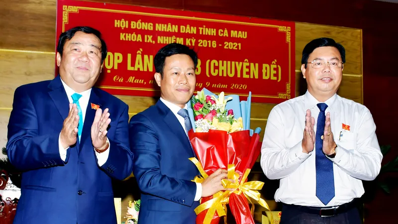 Bí thư Tỉnh ủy Cà Mau Nguyễn Tiến Hải (phải) và Chủ tịch HĐND tỉnh, ông Trần Văn Hiện (trái) tặng hoa chúc mừng tân Chủ tịch UBND tỉnh, ông Lê Quân