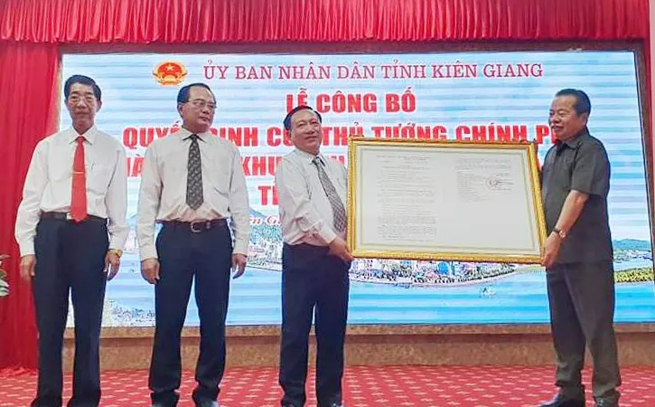 Ông Mai Văn Huỳnh (bên phải), Phó Bí thư Thường trực, Chủ tịch HĐND tỉnh Kiên Giang, thừa uỷ quyền của Thủ tướng Chính phủ trao quyết định thành lập Khu kinh tế cửa khẩu Hà Tiên. Ảnh: KHÁNH THÙY
