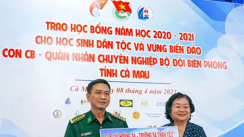 Đại tá Nguyễn Quang Hà, Phó Chính ủy Bộ Chỉ huy Bộ đội Biên phòng tỉnh Cà Mau nhận bảng tượng trưng 100 suất học bổng trị giá 100 triệu đồng do bà Trương Mỹ Hoa trao tặng. Ảnh: BĂNG THANH