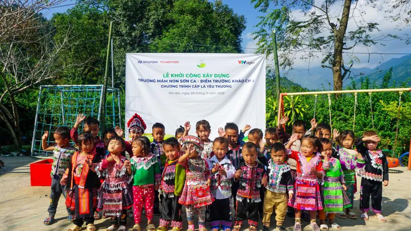 Các em học sinh vui tươi chờ đón điểm trường mới chuẩn bị xây dựng