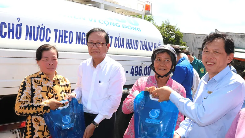  Ông Nguyễn Thanh Sử (thứ 2 bên trái), Phó Tổng giám đốc SAWACO, trao tặng túi nước sạch đến người dân xã Phú Đông, huyện Tân Phú Đông (tỉnh Tiền Giang)