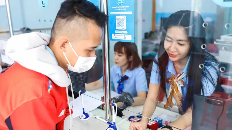 Nhân viên ngành cấp nước hướng dẫn người dân cài app SAWACO CSKH tại quầy giao dịch