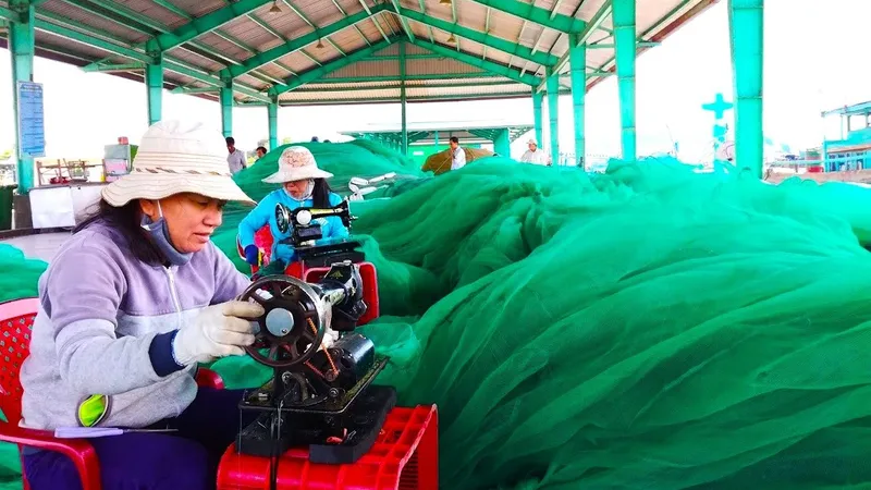 Phụ nữ làng biển ở tỉnh Lâm Đồng cặm cụi vá từng tấm lưới rách