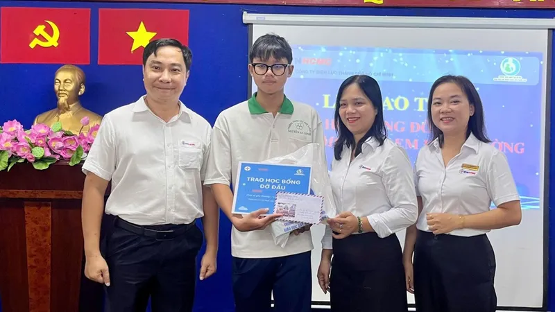 Ông Nguyễn Thanh Nhã, Phó Tổng giám đốc EVNHCMC và đại diện Công đoàn EVNHCMC trao học bổng đỡ đầu cho học sinh tại buổi lễ