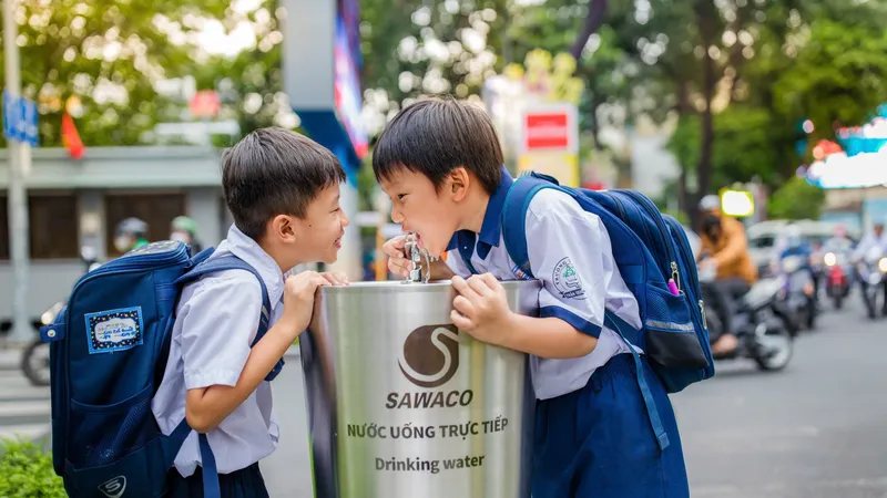 Học sinh thích thú uống nước tại vòi ở TPHCM