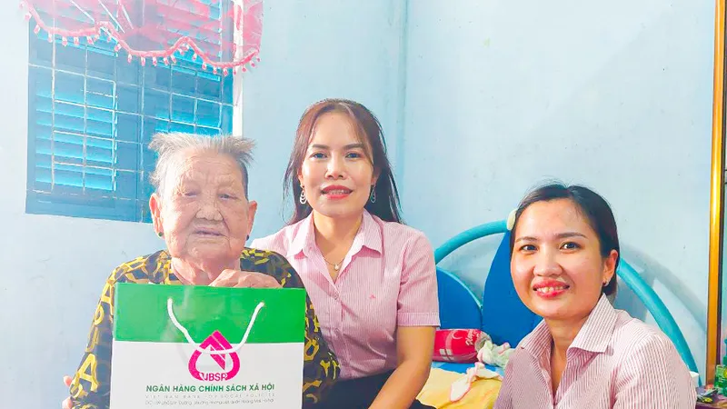 Bà Trịnh Bích Tuyền, Phó Giám đốc phụ trách Ngân hàng Chính sách xã hội Chi nhánh tỉnh Sóc Trăng (giữa) tặng quà cho gia đình chính sách