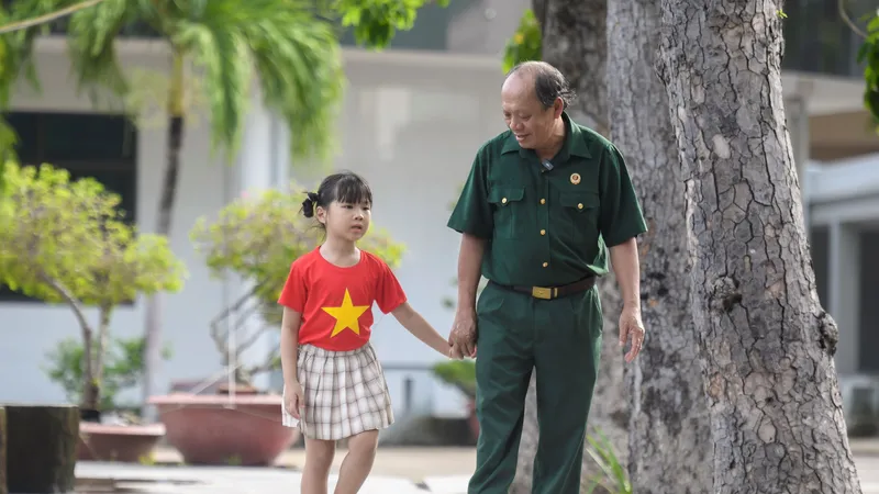 Thượng sĩ Nguyễn Chí Tường cùng con một nhân viên Vinamilk tại Trung tâm Điều dưỡng Thương binh và Người có công Long Đất. Ảnh: THANH BÌNH