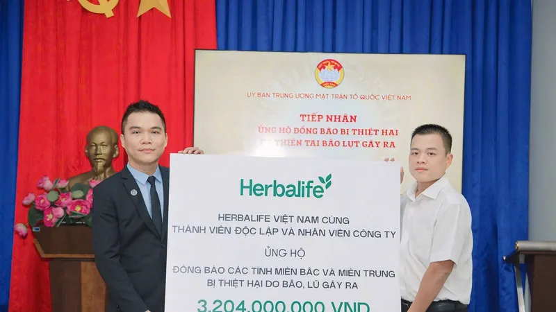Đại diện Herbalife Việt Nam Ông Nguyễn Thành Đạt, Giám Đốc Truyền Thông (áo west đen) trao tiếp nhận ủng hộ cho Ông Nguyễn Hải Nam