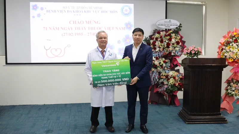 Đồng chí Hồng Quang, Thành viên HĐQT, Chủ tịch Công đoàn Vietcombank (bên phải) trao biển tượng trưng hỗ trợ 500 triệu đồng cho Bệnh viện Đa khoa Khu vực Hóc Môn