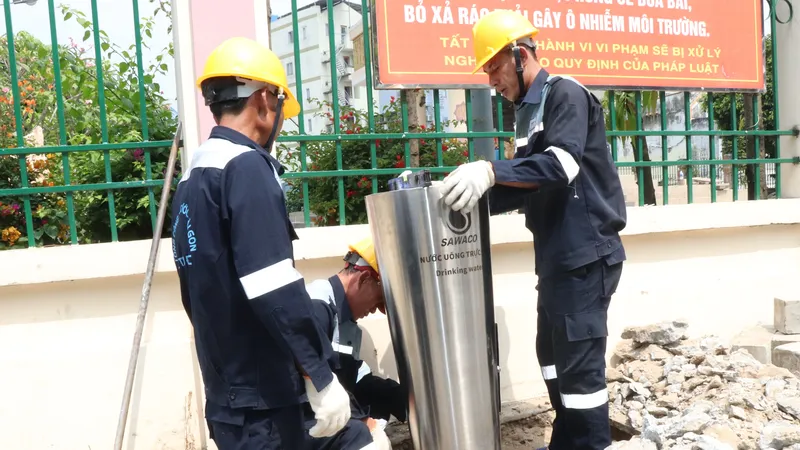 Công nhân ngành cấp nước thực hiện lắp đặt trụ nước uống tại vòi ngày 9-3